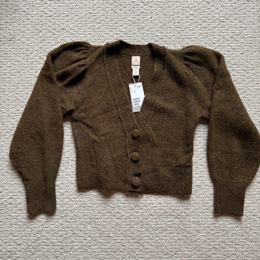 Olive green knit cardigan with oversized buttons and balloon shoulders